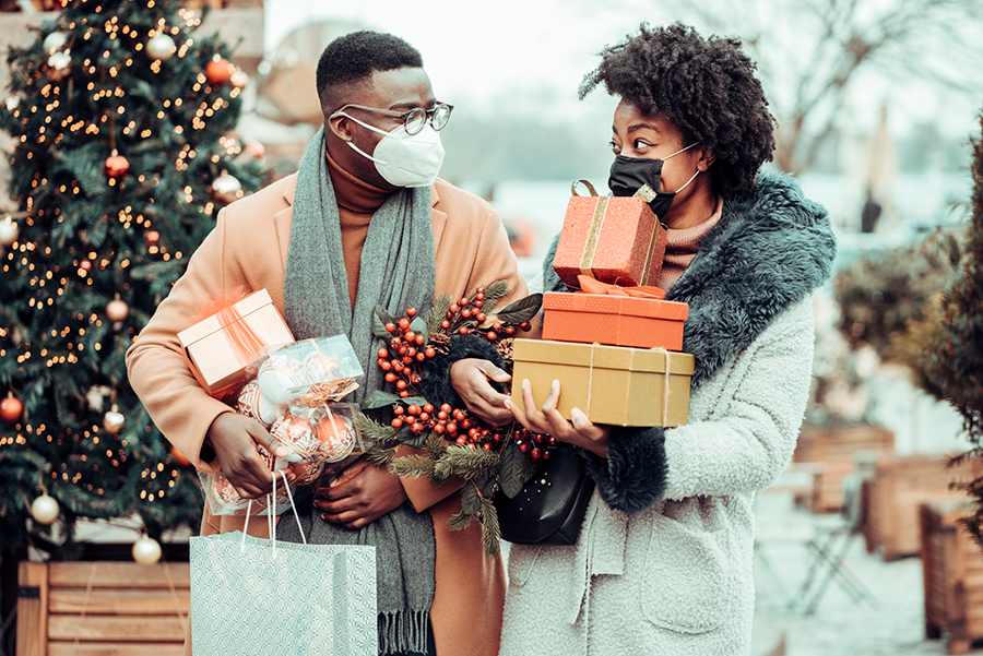 Man and woman wearing protective face masks and shopping during the holidays.