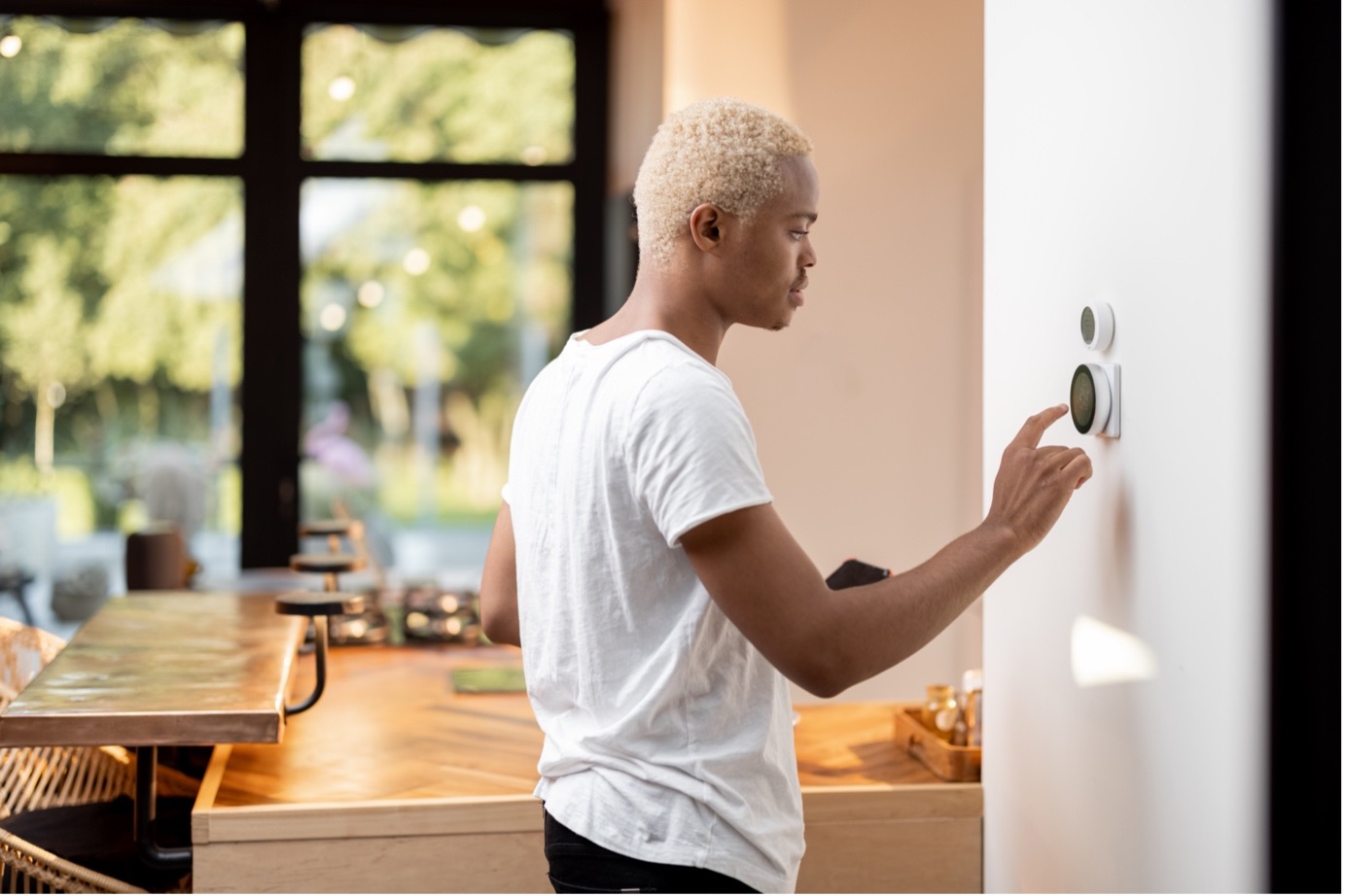 Man changing the temperature in his home.