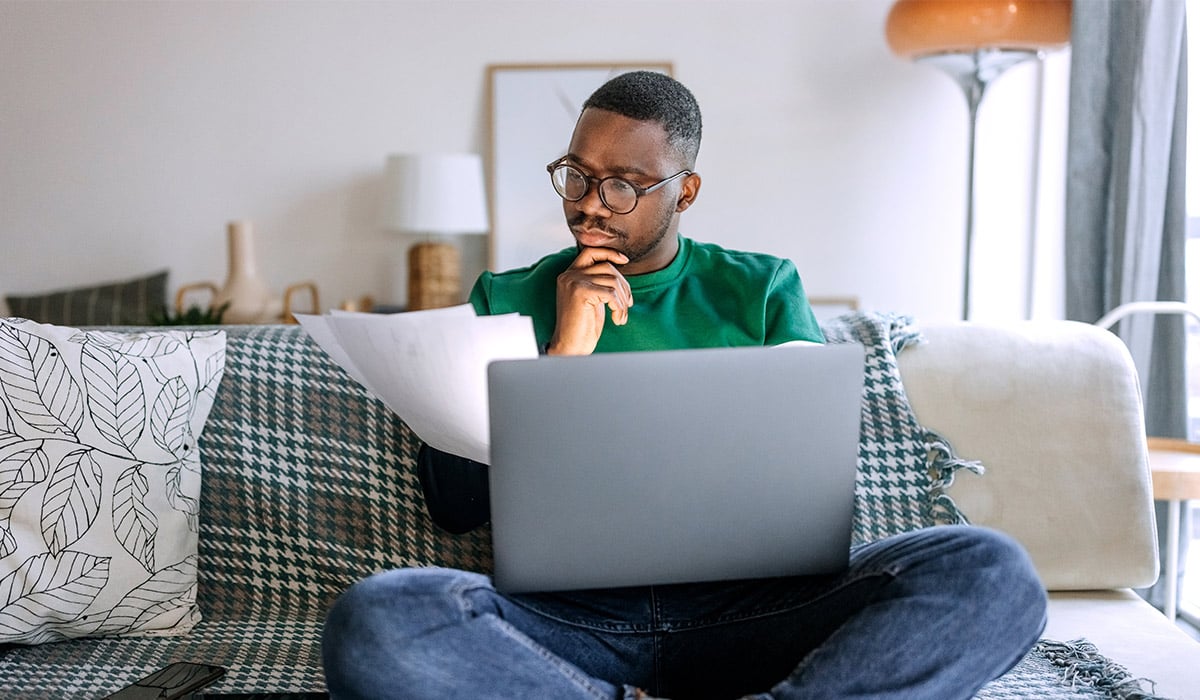 Man on Laptop and Reviewing IRS Documents