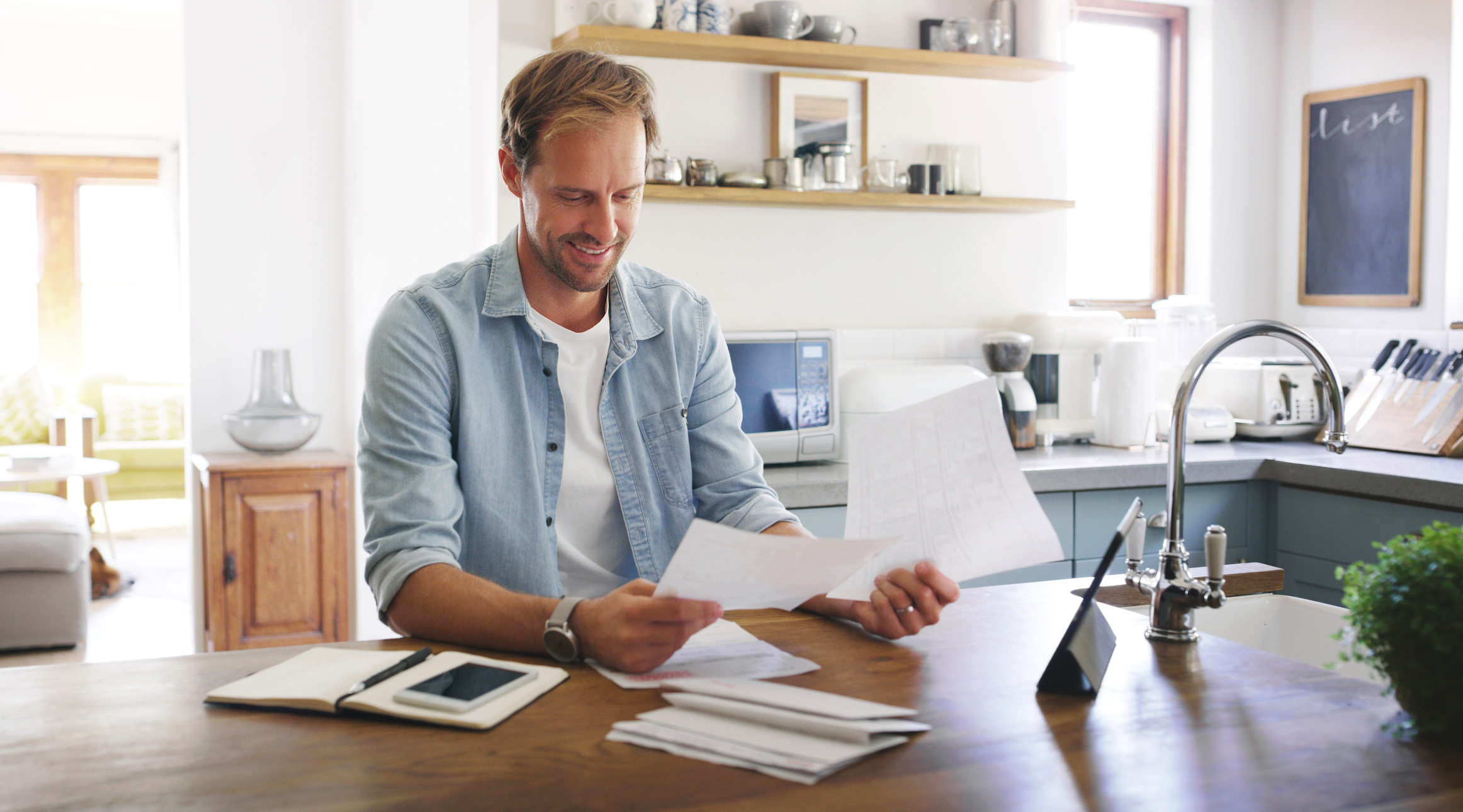 A man smiles while looking through financial documents