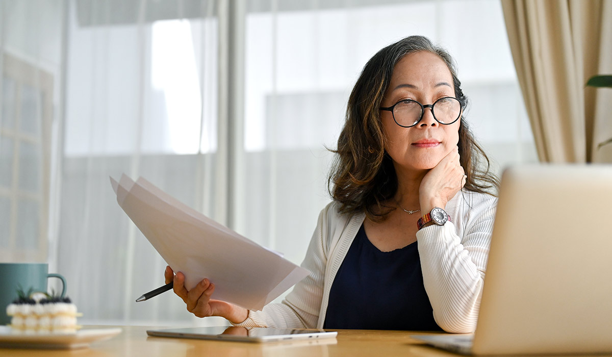 Woman Working on her Budget with Laptop - Xact Loans